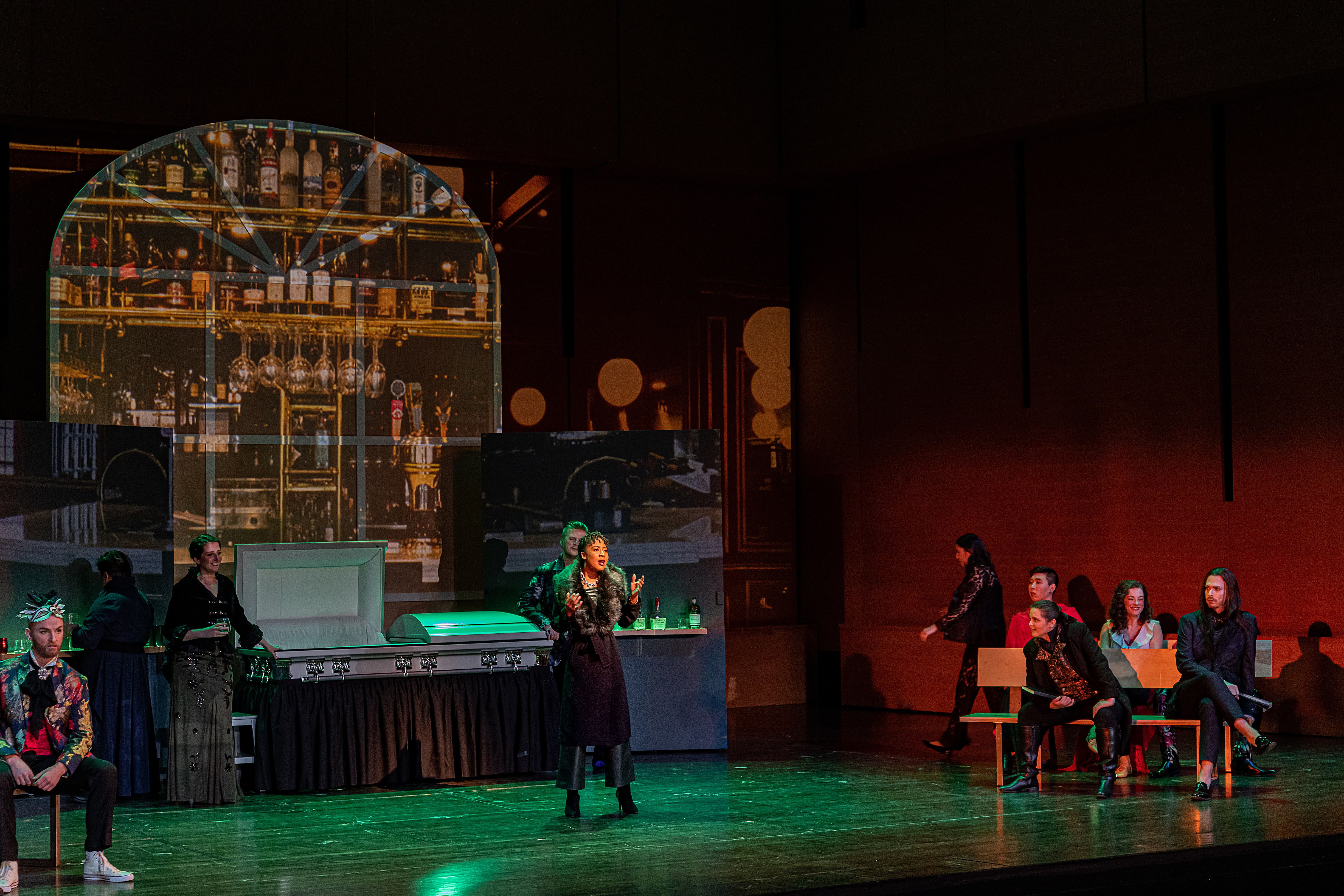 A performer stands center stage in front of an elaborate set.